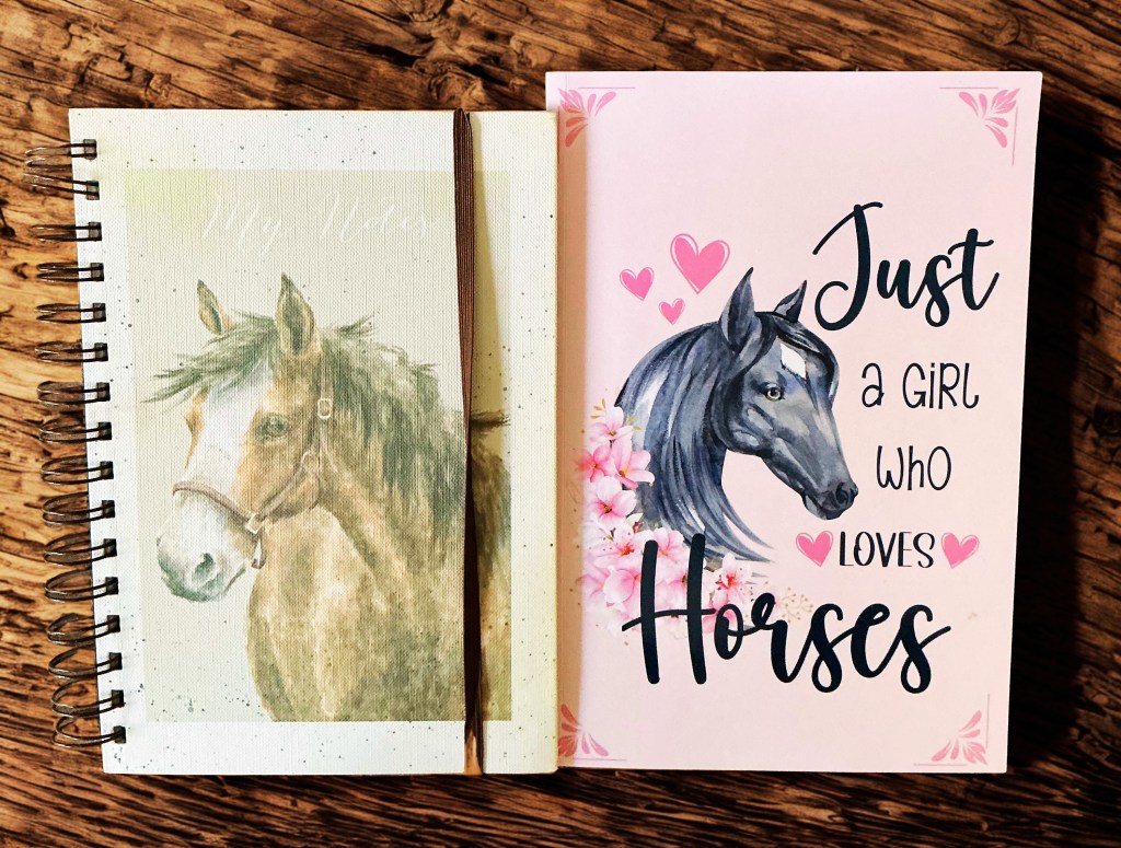 A spiral-bound notebook featuring a watercolor image of a brown horse on the cover, with the text 'My Notes.' Next to it is a card that reads 'Just a Girl Who Loves Horses,' adorned with an illustration of a black horse and pink hearts.